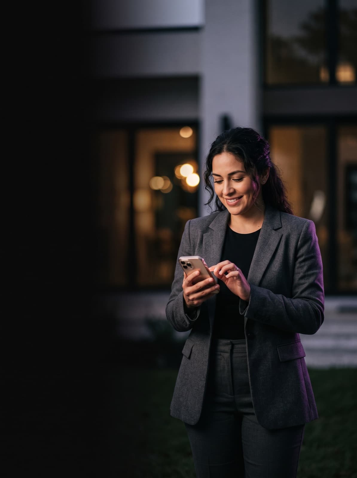 A real estate agent outside a home at dusk, texting her Engentfy assistant on WhatsApp